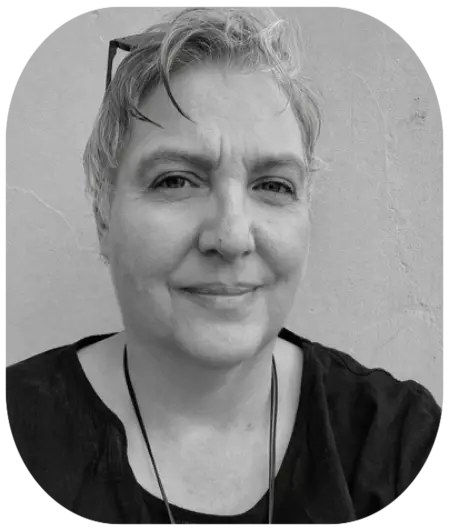 Schwarz-Weiß-Porträt von Colette Walter, Eventmanagerin bei Autismus Kunterbunt, lächelnd vor einer hellen Wand.